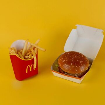 A McDonald's fries and burger on a yellow background